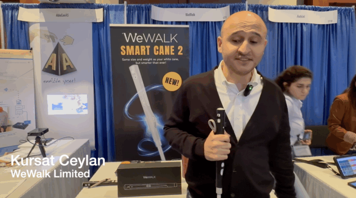 Kursat Ceylan demonstrating WeWalk Smart Cane in front of WeWalk booth at ATIA conference